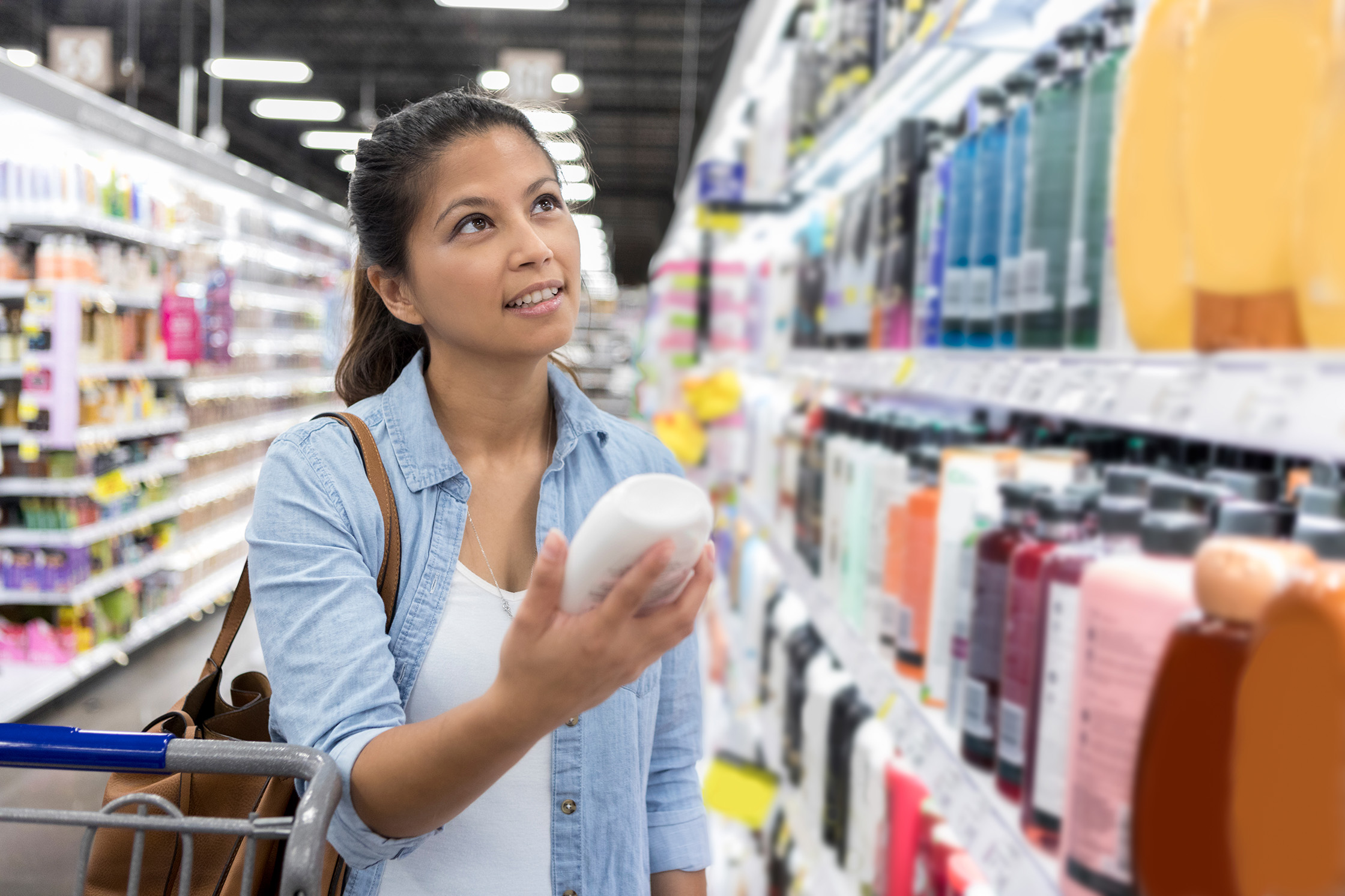 Woman shops for shampoo in her local supermarket
