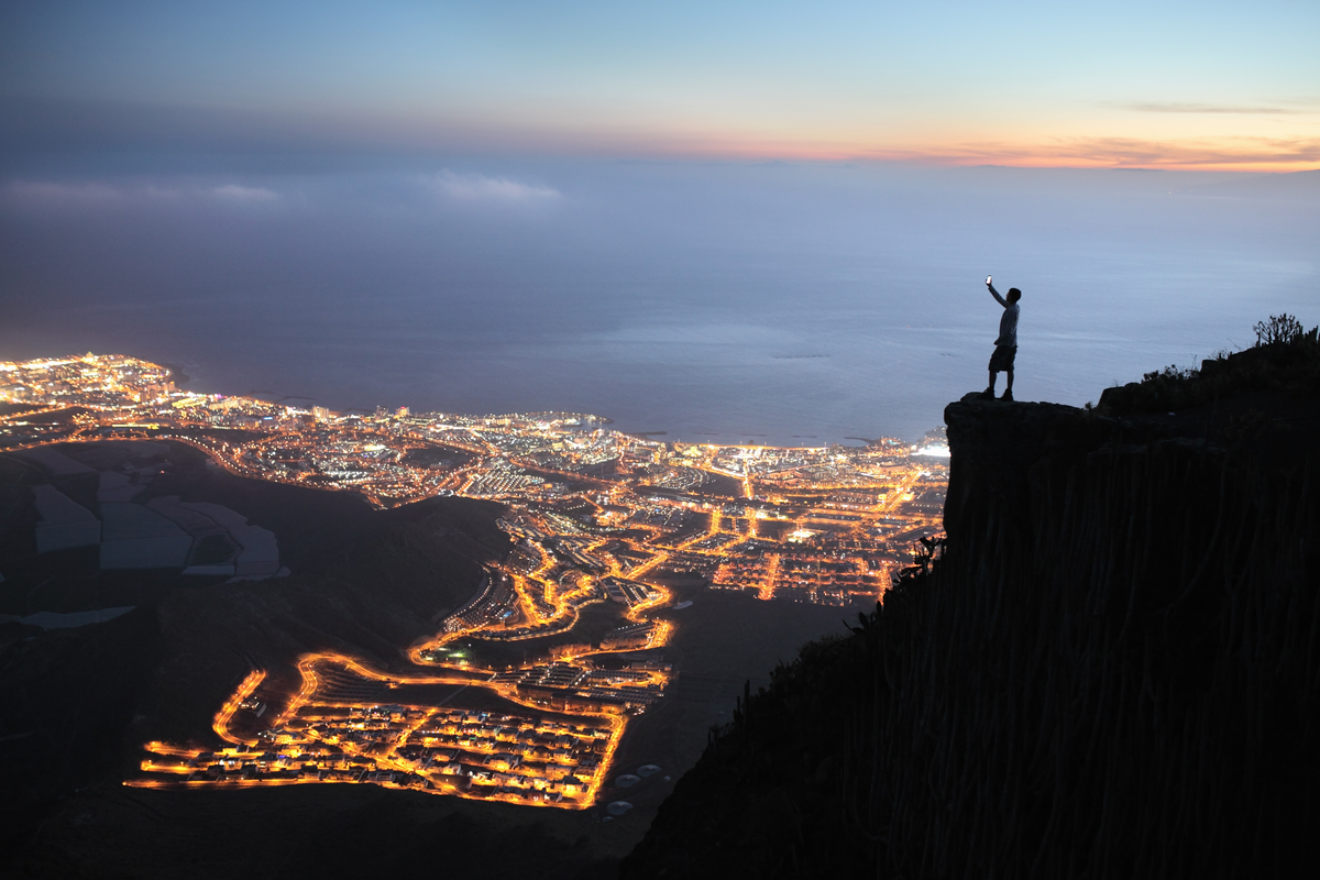 Man with mobile device at night city view