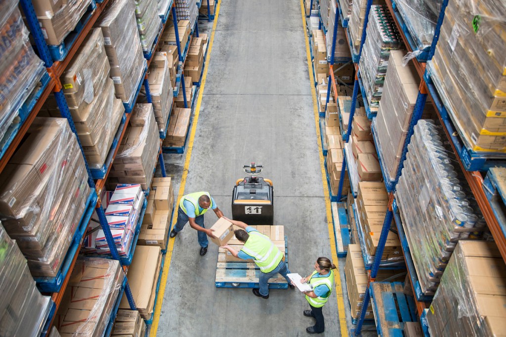 Workers unloading pallet inside a food distribution warehouse