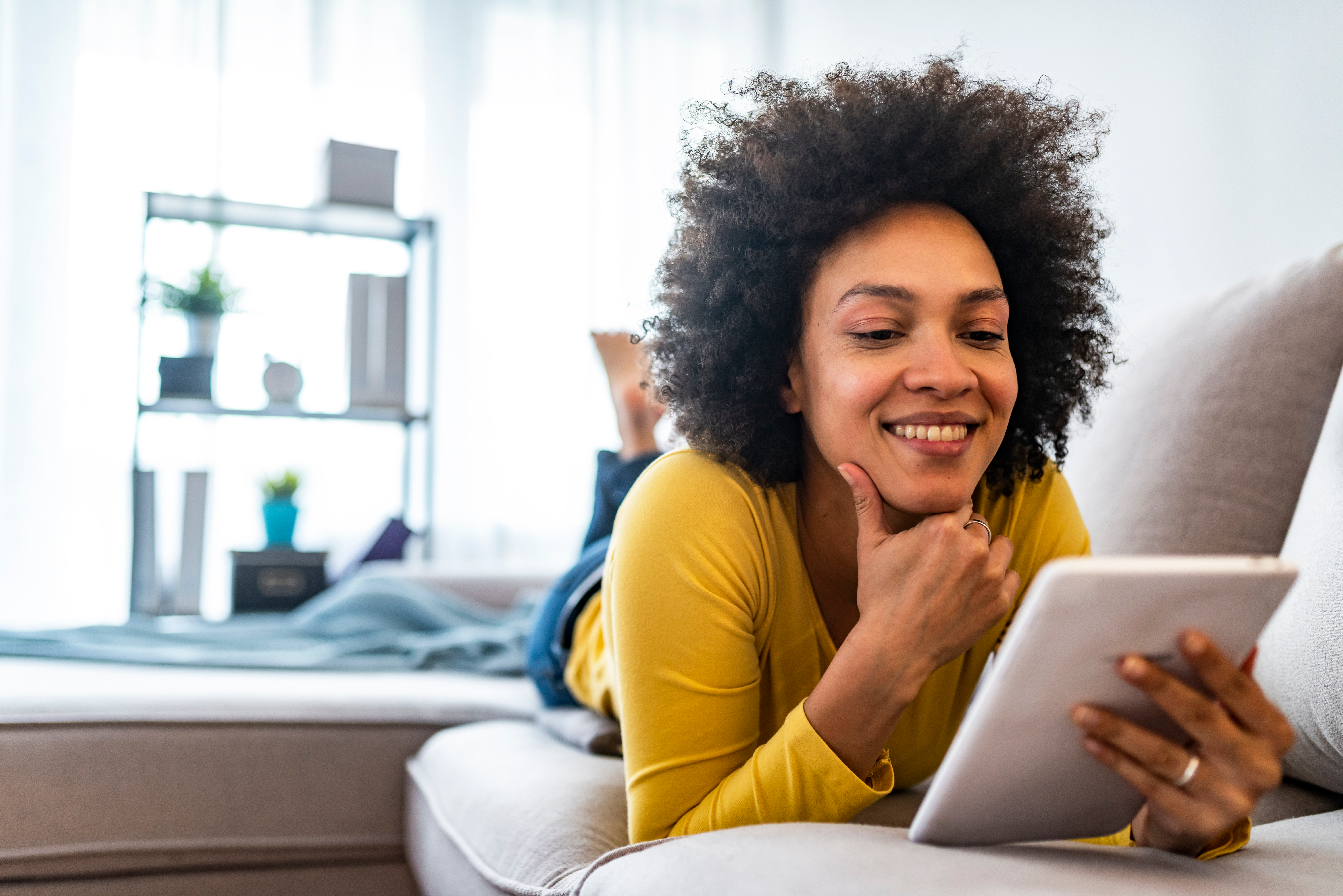 Girl in a living room with a tablet in hands