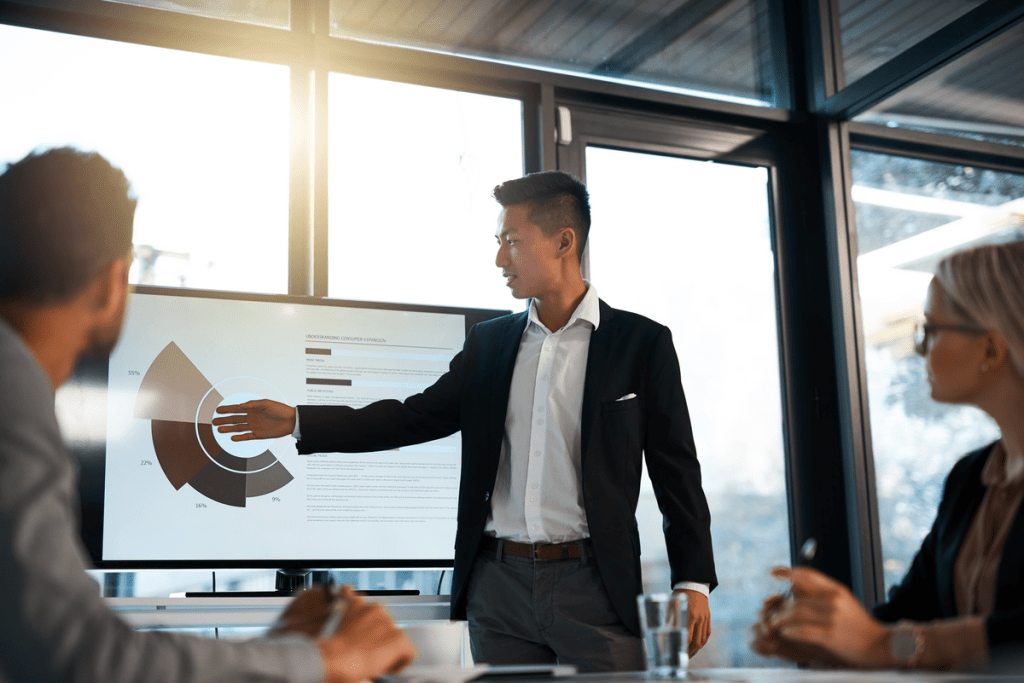 Asian business man presents in a meeting room some charts with his colleagues