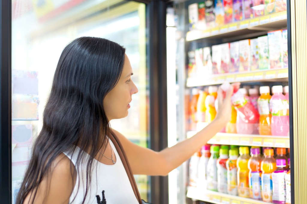 Woman shopping for a drink in corner store