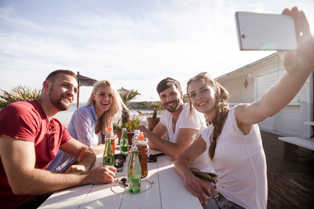 Group of friends taking a self portrait in beach bar