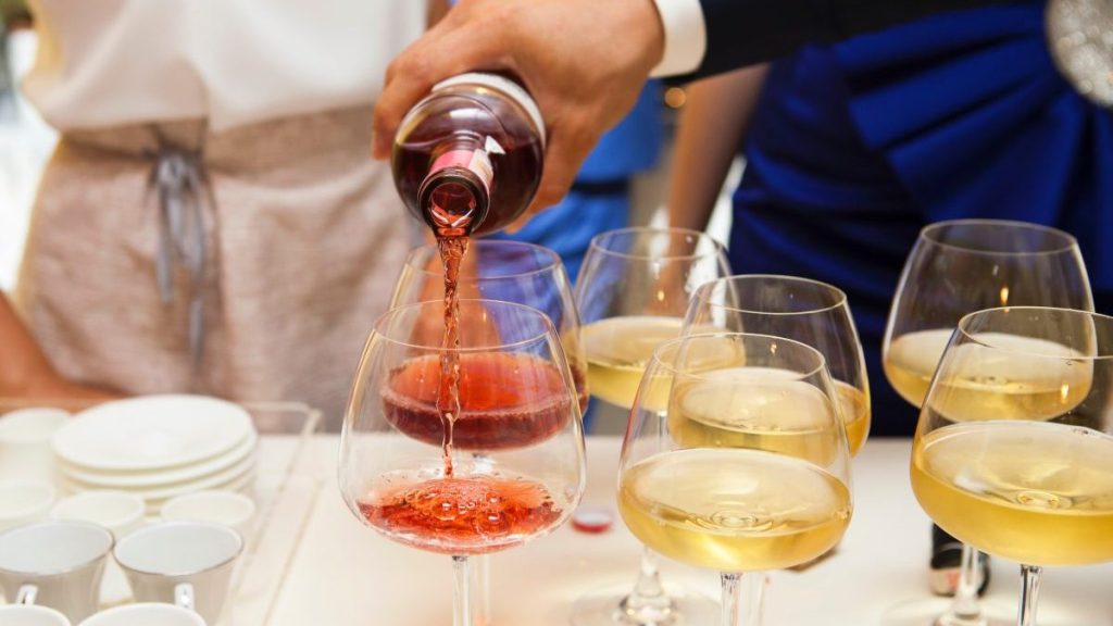 A hand pouring glasses of BFY wine from the bottle.