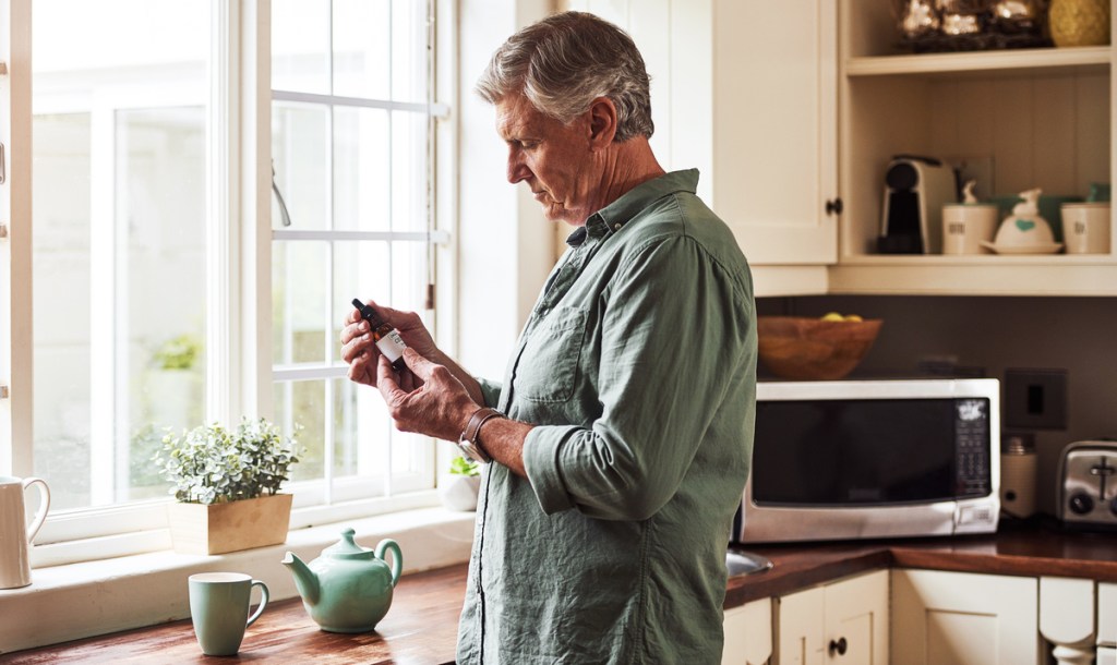 Man looks at CBD supplement purchased from the US cannabidiol market