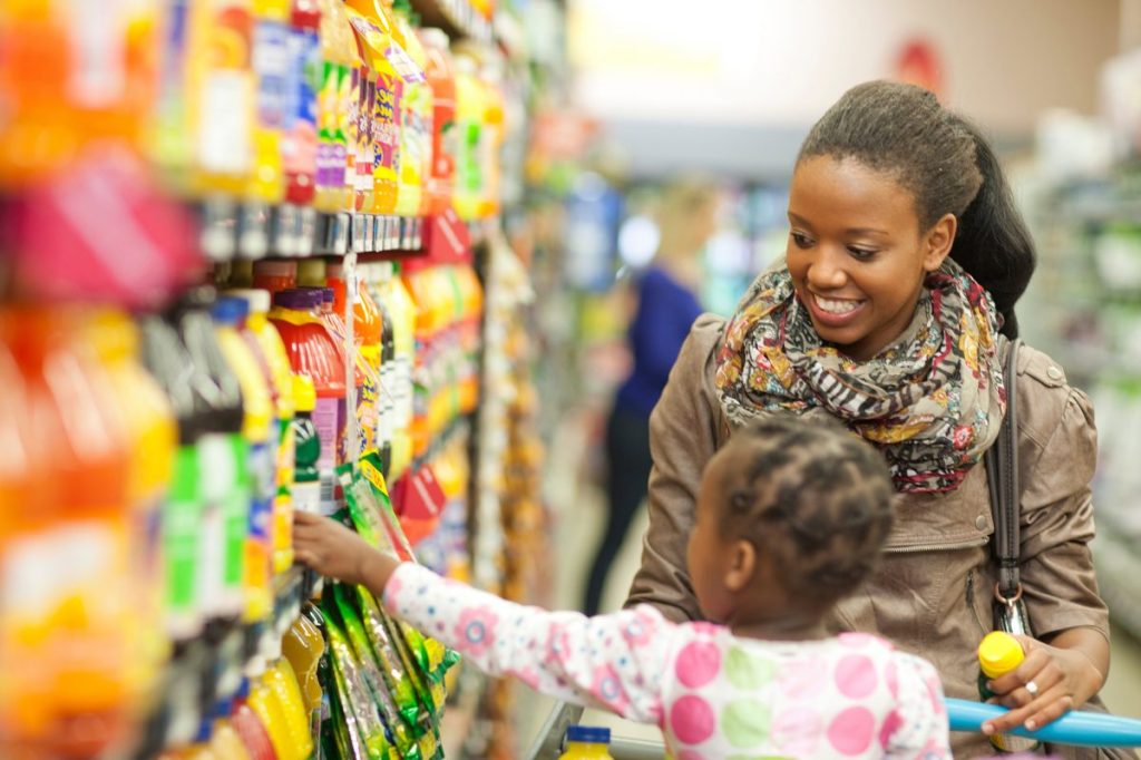grocery shoppers reaching for trending products in the store
