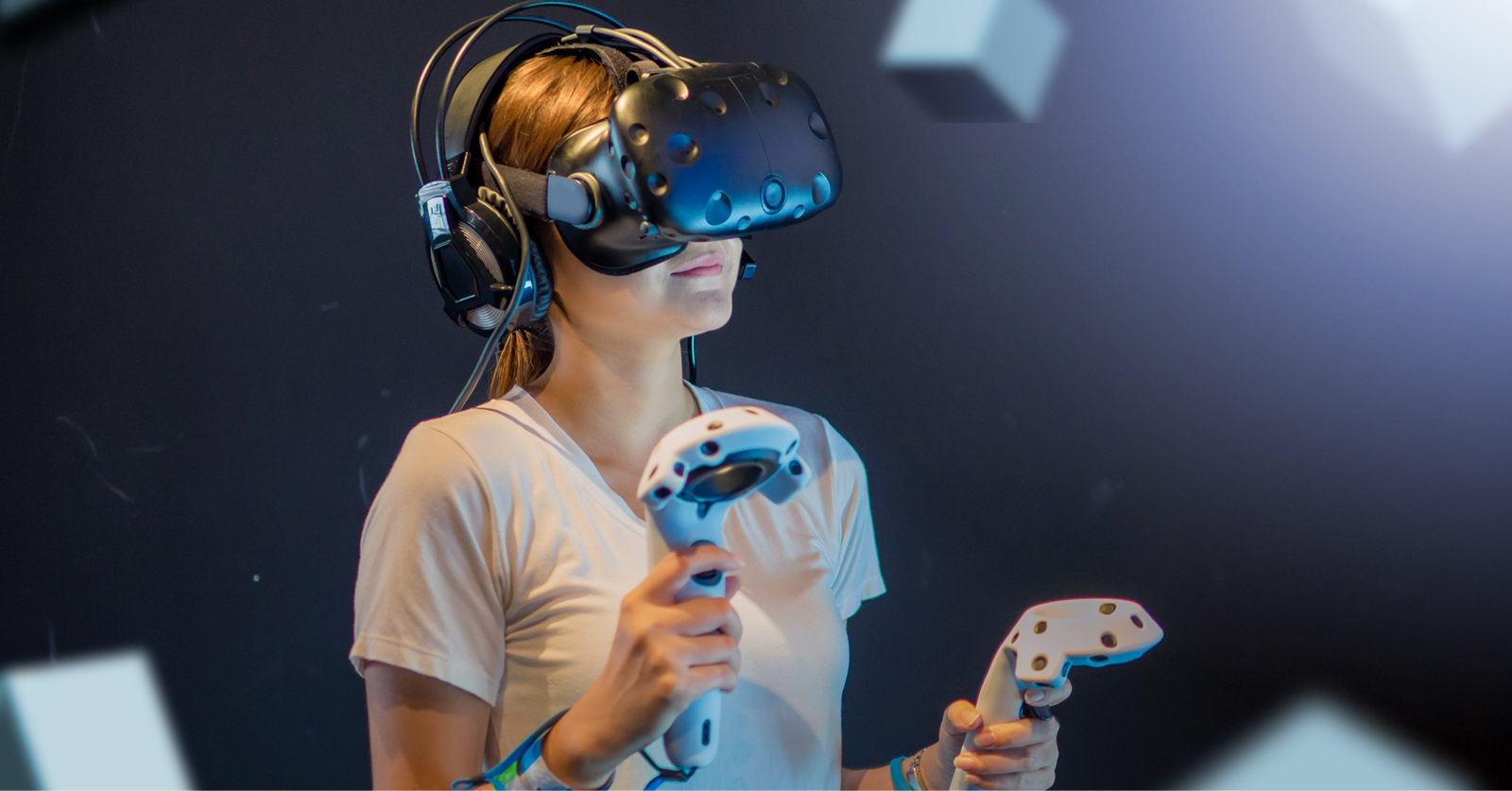 Energetic young woman wearing virtual reality headset and holding hand controllers