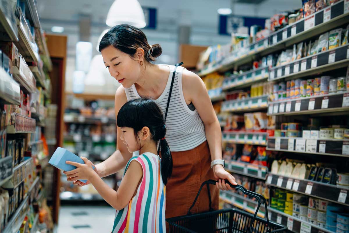 A Japanese woman and her daughter look at a package in a store