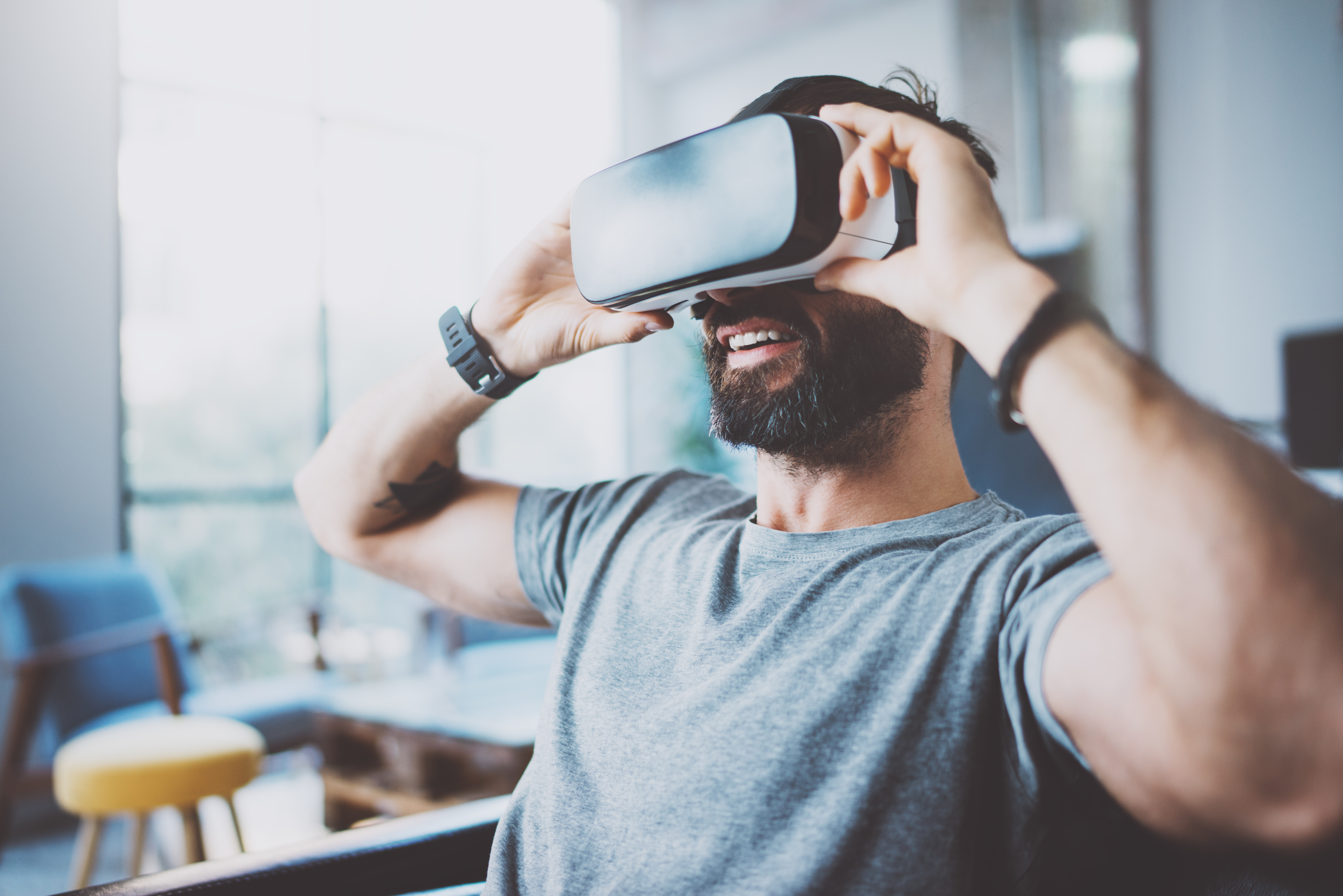 phygital reality man wearing AR virtual reality glasses at home