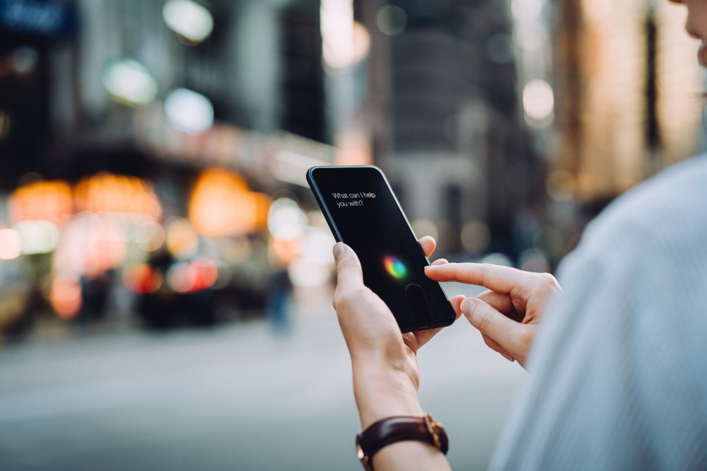 close up shot of someone interacting with their mobiel device on a busy street