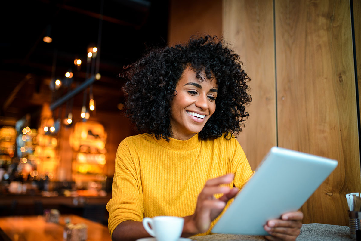 Smiling woman using digital tablet.