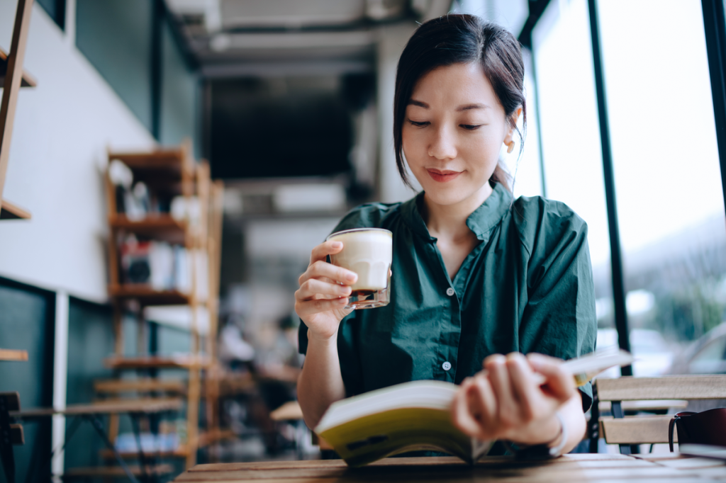 Woman drinking coffee and reading a book