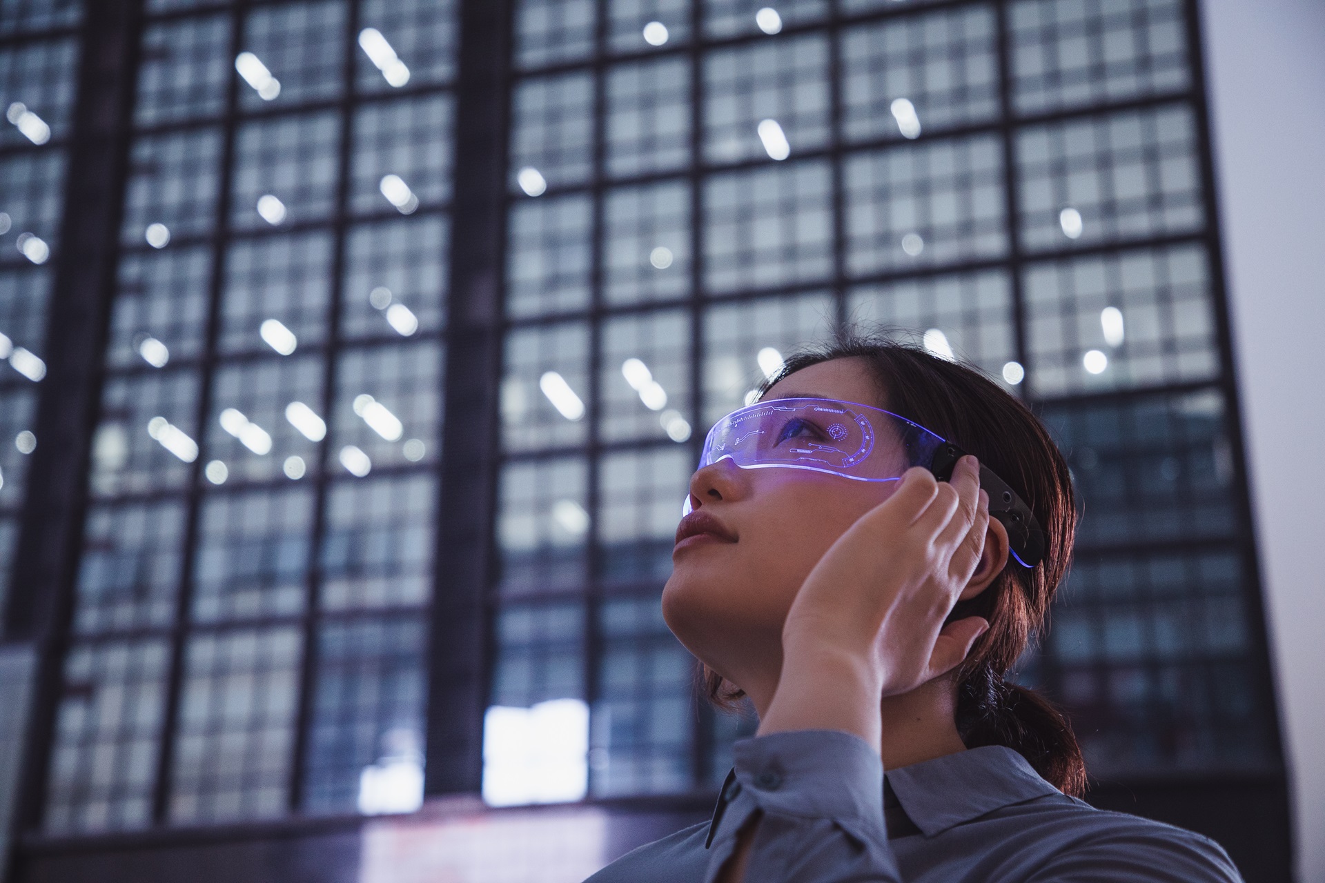 asian woman using a smart glasses in front of an office building (the glassed used in the shot is a generic product in China)