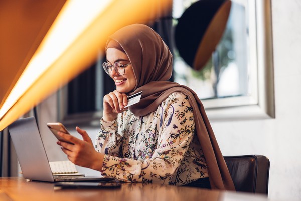 Woman in headscarf looks at her cell phone