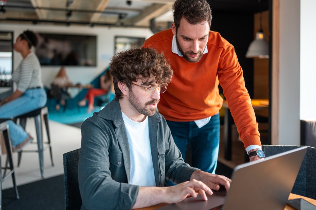 hommes dans un bureau lisant des analyses sur ordinateur - insights PGC FLS