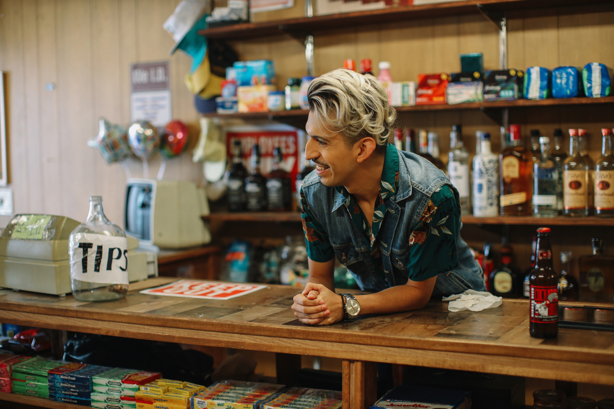 Portrait of the owner or a manager at the counter in a small local business American convenience store (bodega), in Los Angeles, California