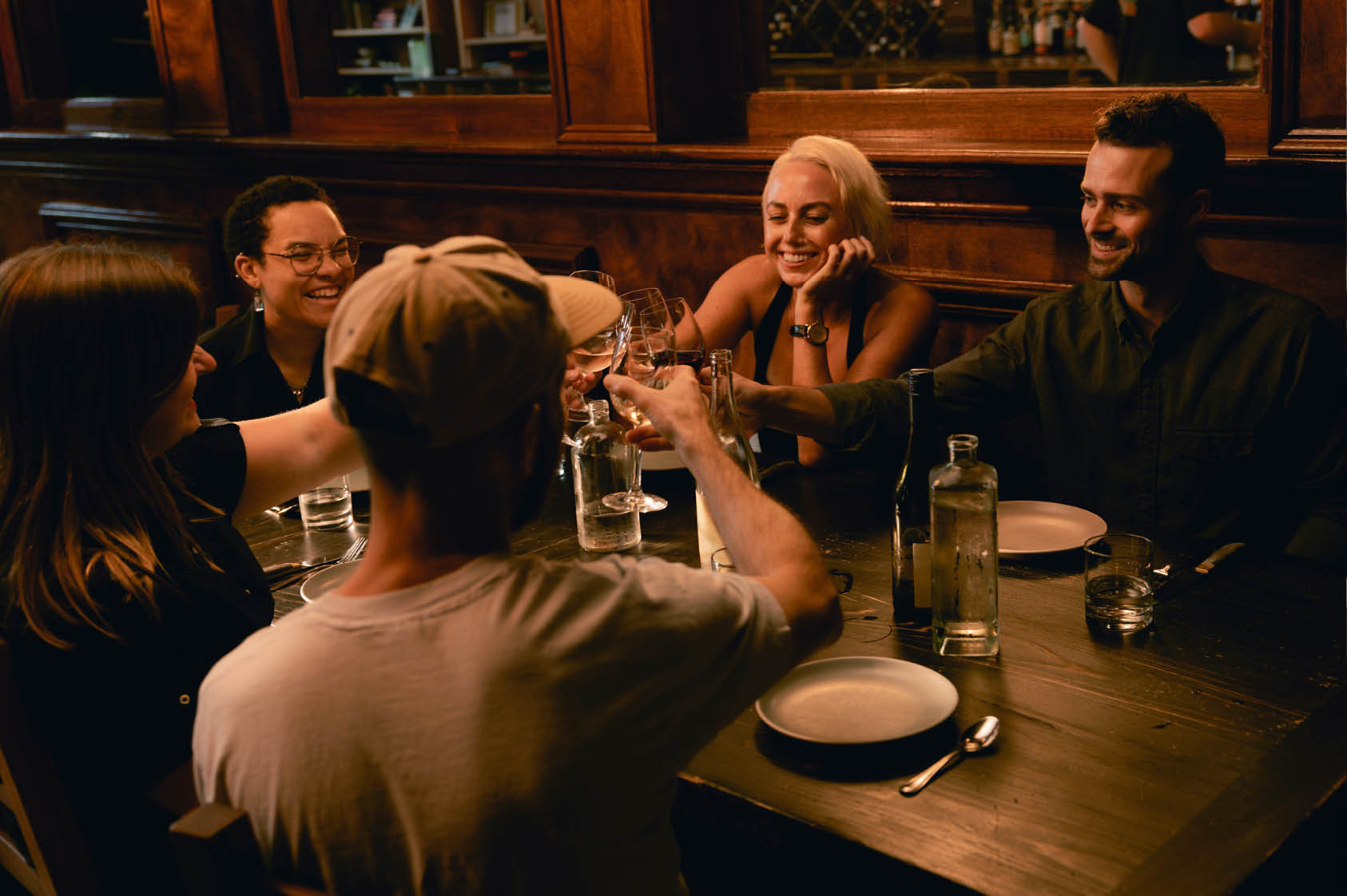 Consumers interacting with digital ordering kiosks in a modern restaurant setting.