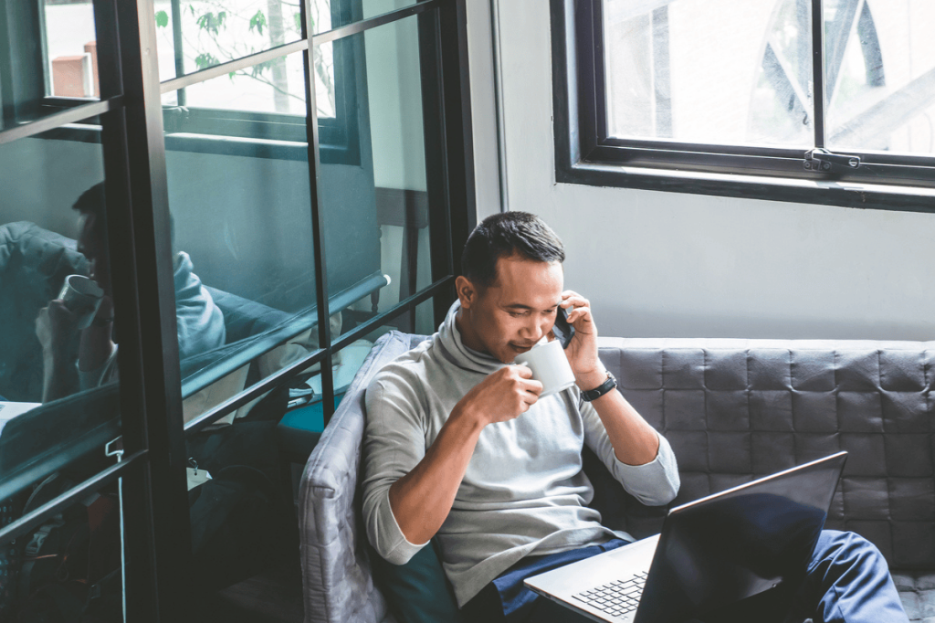 man using his phone while he is talking in a meeting

