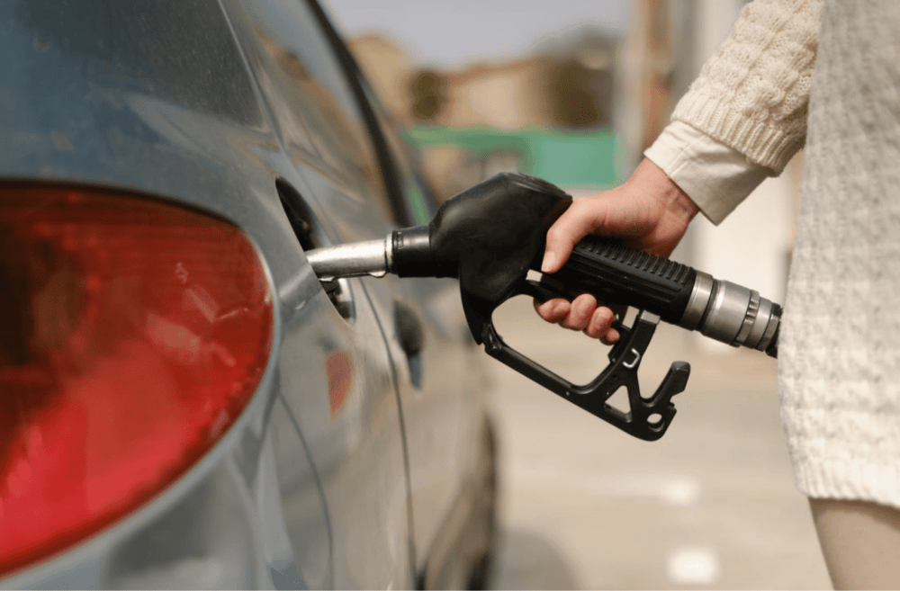 person fueling his car with oil