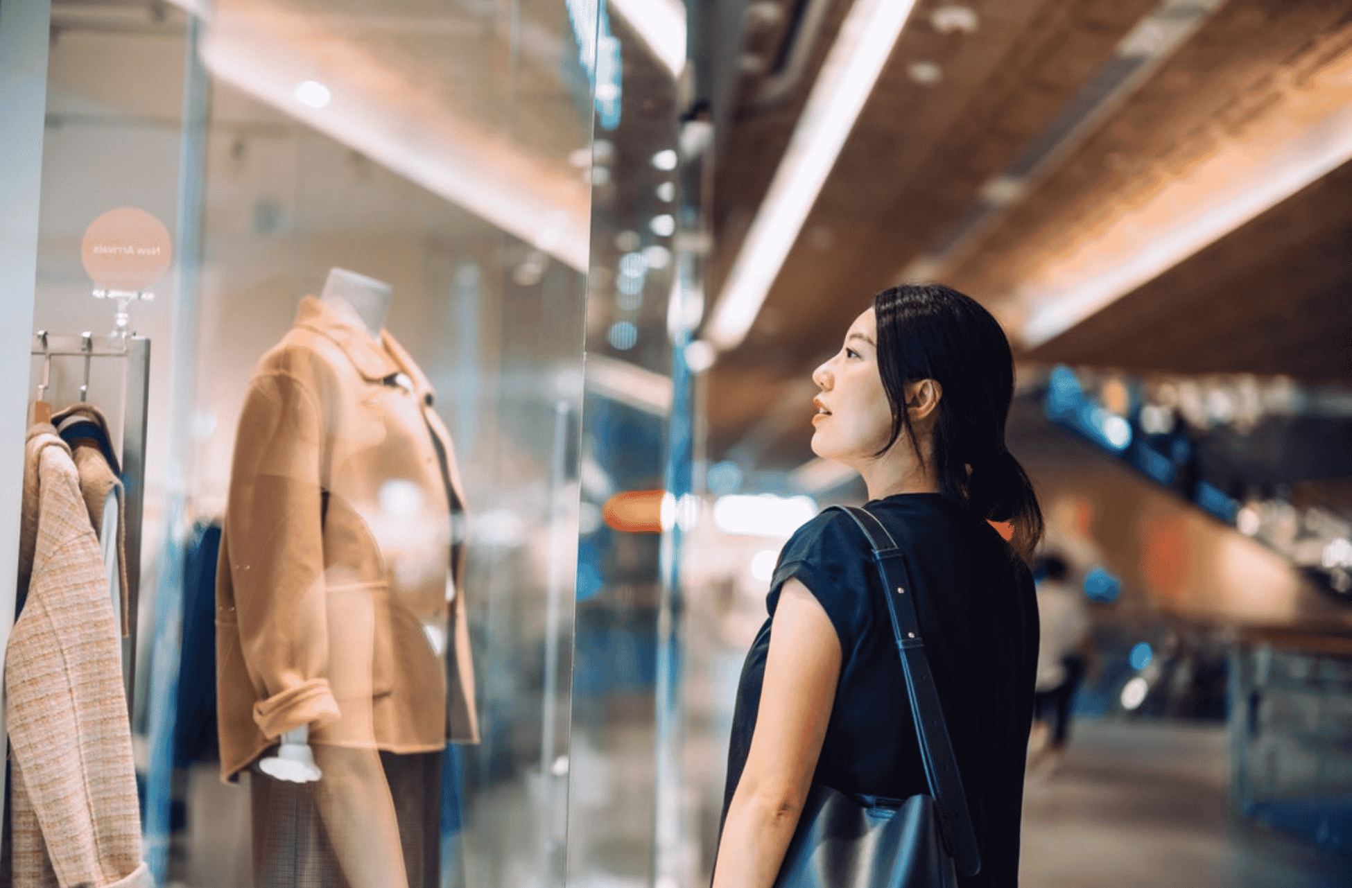 women looking at a dress in a window