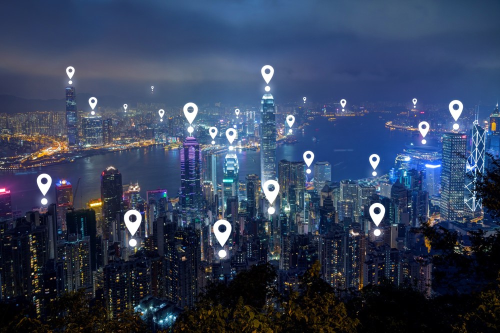 Map pin icons on Hong Kong's skyline at dusk.