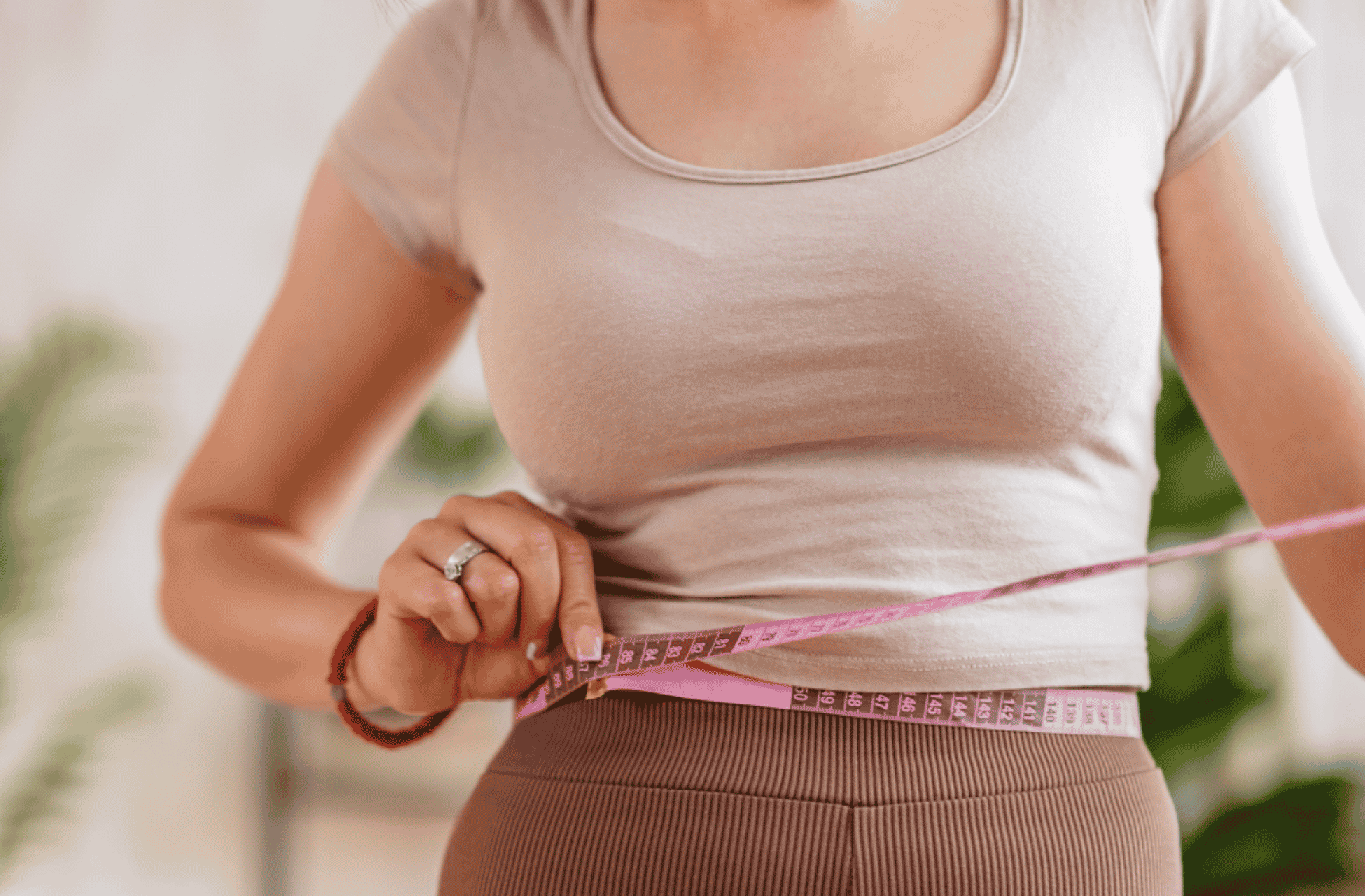 women measuring herself for fitness purposes