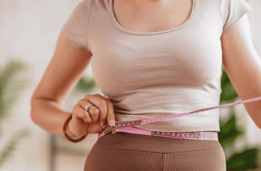women measuring herself for fitness purposes