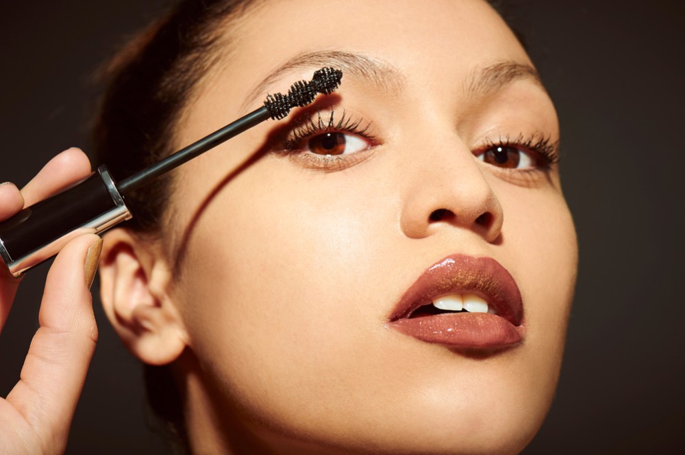 women using makeup in a dark backrgroun